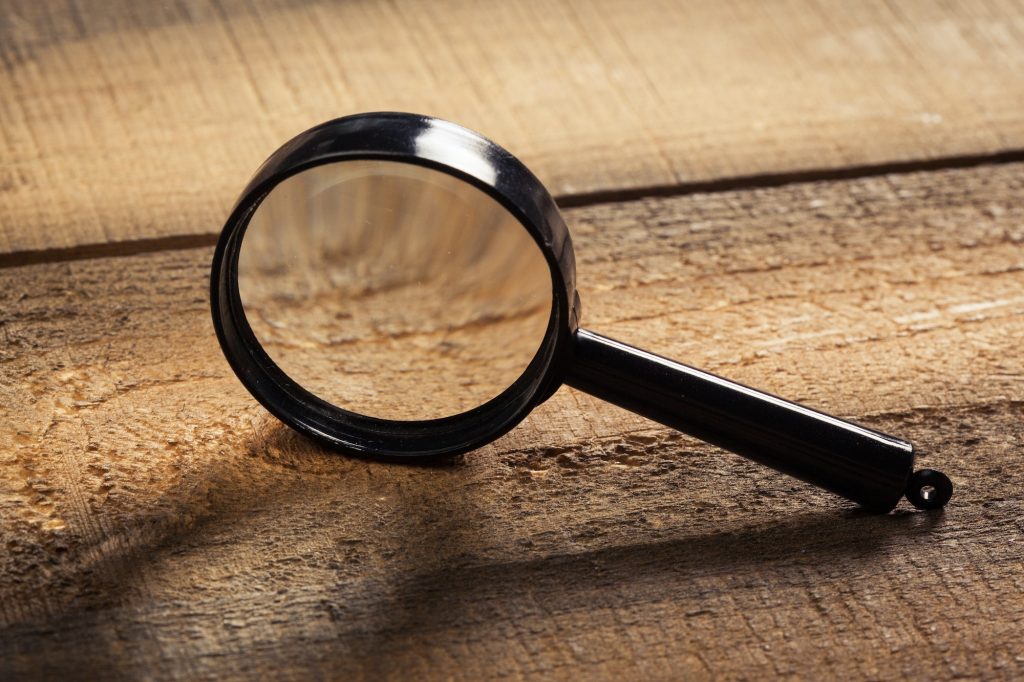 magnifying glass on the wooden background